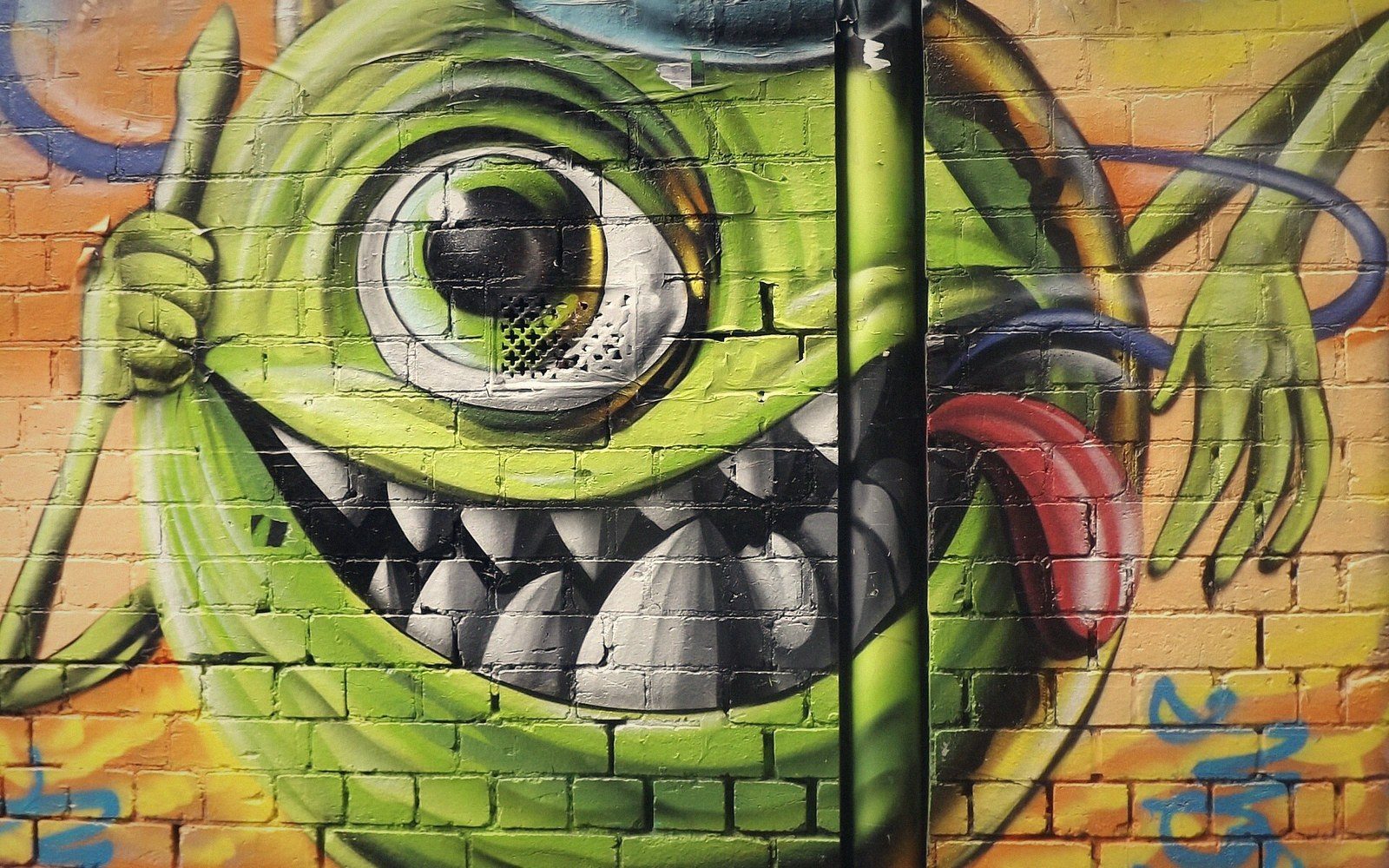 Green one-eyed monster character spray-painted on a brick wall in Hosier Lane
