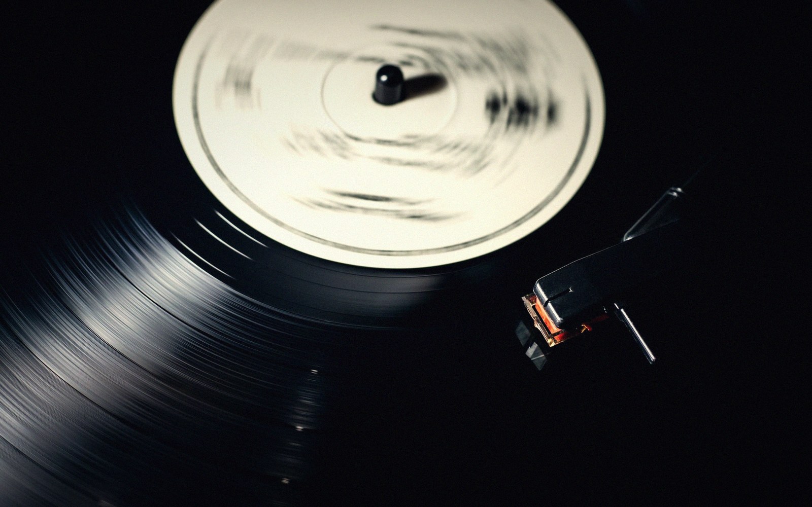 A vinyl record spins on a turntable as the tonearm hovers nearby